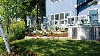Completed landscape with stone planting beds and established lawn