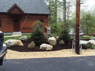Contemporary home entry with gravel and evergreen landscaping