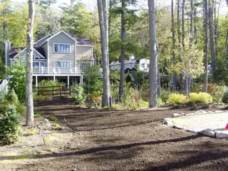 Freshly graded lawn area before two-story lake house