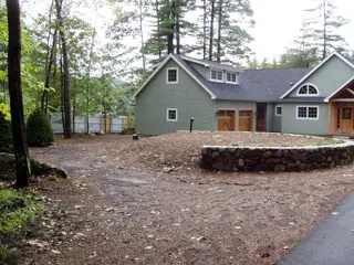 Gravel driveway with stone walls and forest borders
