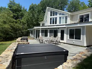 Hot tub and patio furniture on stone-walled deck