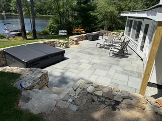 Lakefront patio with kayaks and boat dock view