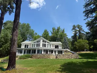 Lakeside home front view framed by tall pine