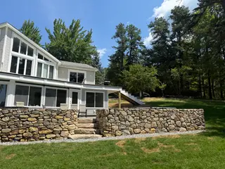 Lakeside home side view with screened porch and stone steps