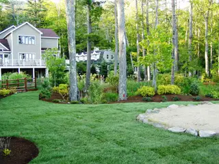 Newly established lawn beside two-story lake house
