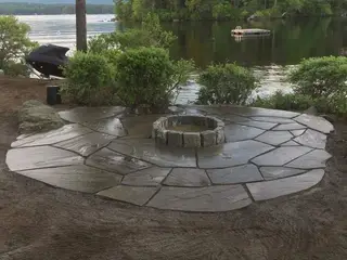 Slate patio fire pit gathering space with stone retaining wall