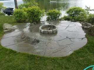 Slate patio with circular stone fire pit overlooking lake