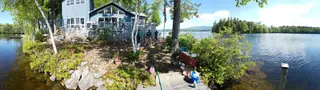 Waterfront boathouse with wooden decking and shoreline plantings