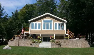 Waterfront home with masonry retaining wall and stone landscaping