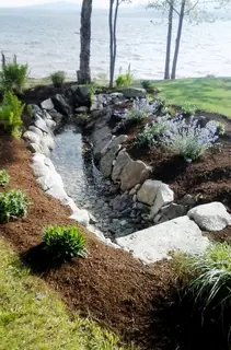 Waterfront stream with stone retaining and flowering plantings