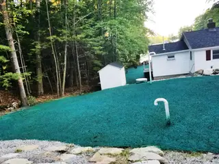 Hydroseeding application with spray hose in forested setting