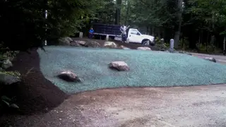 Hydroseeding crew working roadside slope with landscape truck