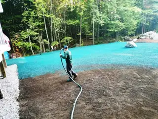 Hydroseeding operation on waterfront with spray hose application