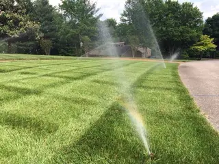 Sprinklers running beside driveway