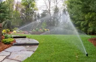 Sprinklers watering terraced backyard garden
