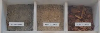 Display bins of stonedust, sand, and wood chips