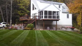 Fall backyard with striped lawn and multi-level deck