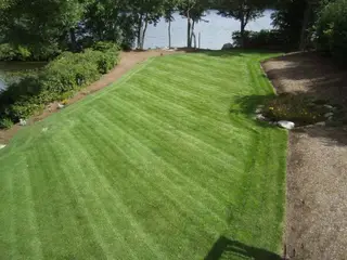 Lakefront lawn with mulch edging and boulder