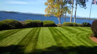 Lakeside lawn with American flag and mature pines