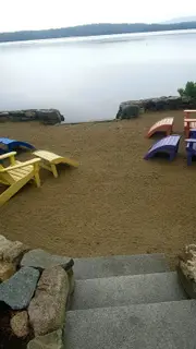 Sandy beach with colorful Adirondack chairs