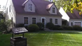 Striped front lawn with wishing well planter
