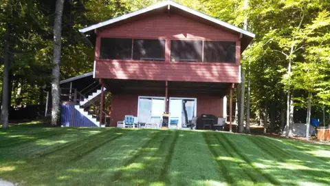Freshly striped lawn at a red lakeside cottage