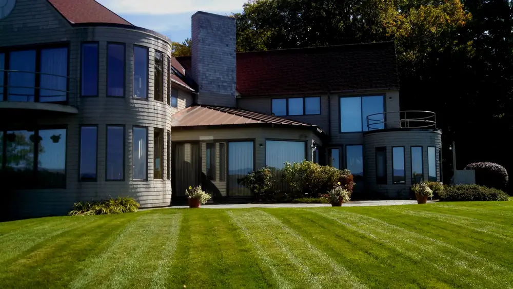 Striped lawn surrounding a contemporary Lakes Region home