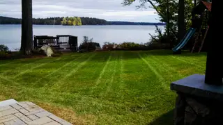 Striped lawn between lakefront dock and play set