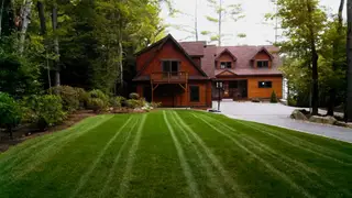 Striped lawn in front of lakeside chalet home