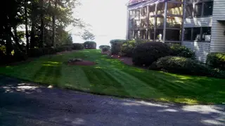 Terraced striped lawn beside lake home