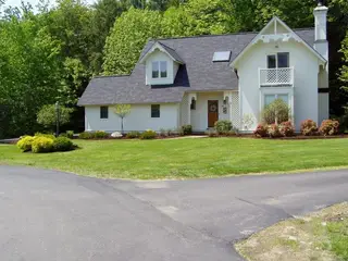 Victorian-style home with striped front lawn