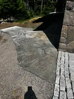 Bluestone patio slab meeting granite curbing