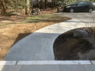 Bluestone walkway curving toward driveway