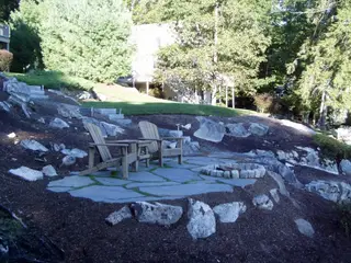 Boulder-lined fire pit patio on hillside