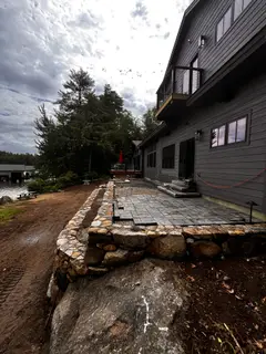 Boulder retaining wall beneath elevated deck patio