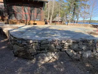 Circular flagstone patio on stacked stone foundation