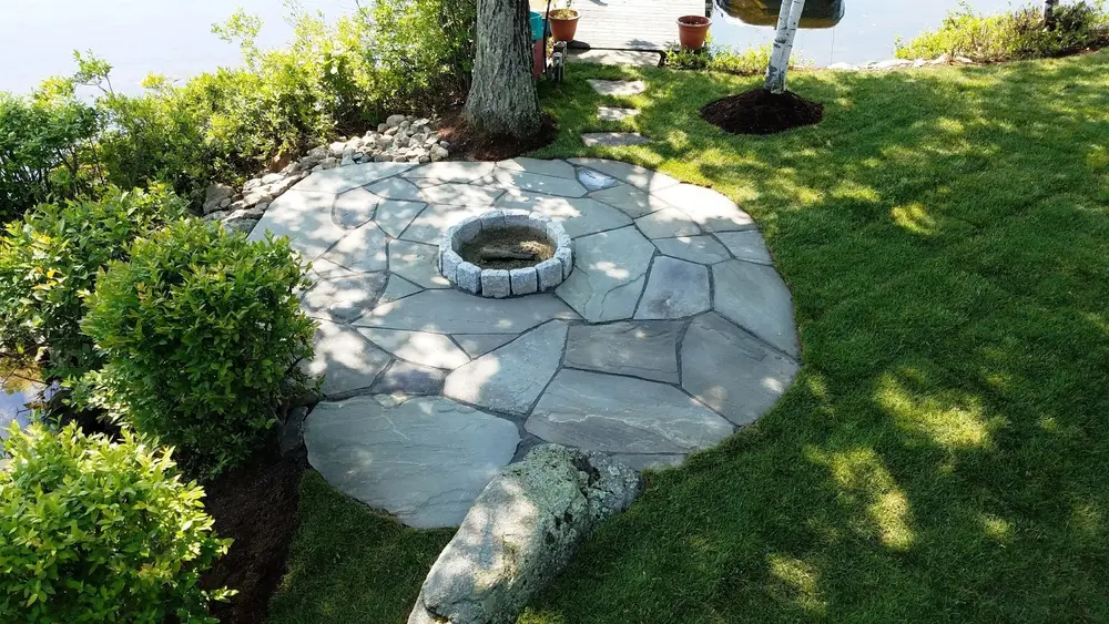 Circular flagstone patio and fire pit beneath a mature tree