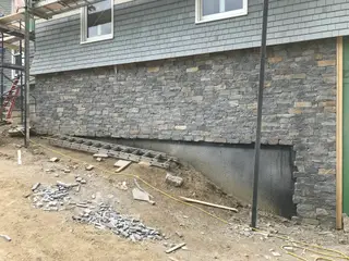 Completed ledgestone veneer wall on house foundation