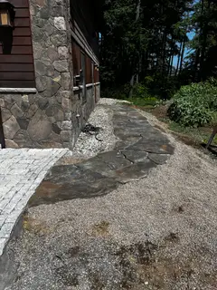 Dark stone retaining wall against gravel slope