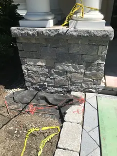 Dry-stack stone pillar corner with granite base