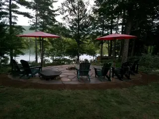 Fire pit patio with red umbrellas among pines