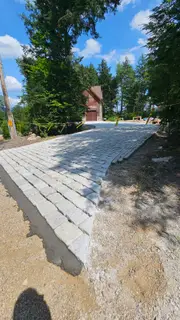 Granite cobblestone driveway nearing stone garage