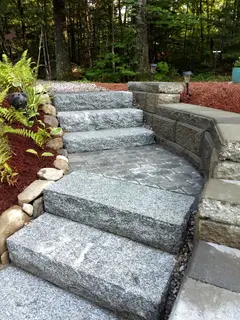 Granite steps meeting curved paver wall