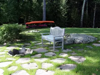 Grass-jointed flagstone seating area with boulder