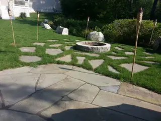 Grass-jointed patio with fire pit and tiki torches