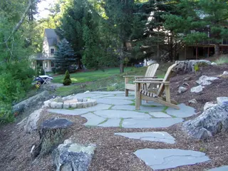Hillside fire pit patio with stone fire ring