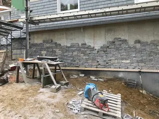 Ledgestone veneer wall installation on house exterior