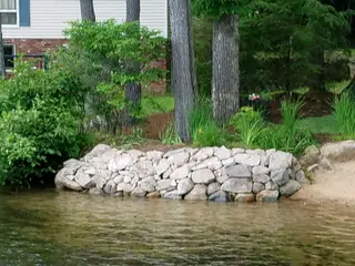 Natural stone shoreline wall at water's edge