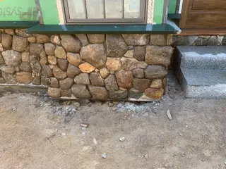 River rock veneer foundation wall under construction