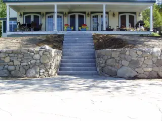 River-stone walls flanking granite staircase to porch